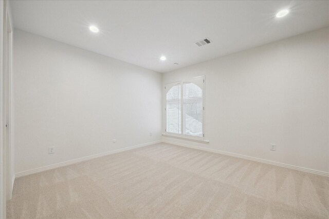 spare room featuring light colored carpet