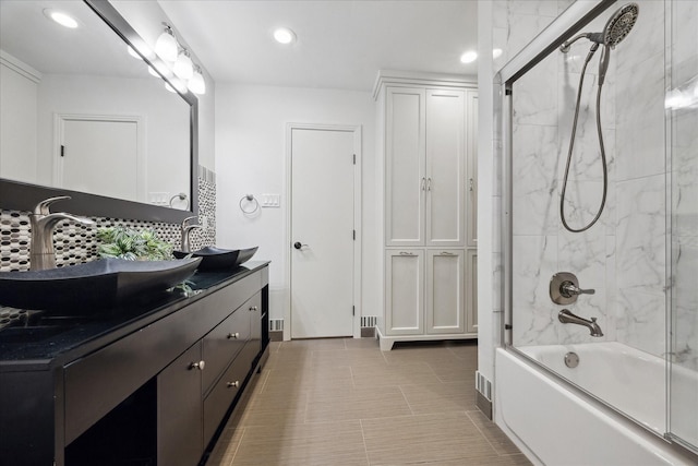 bathroom featuring tasteful backsplash, vanity, and enclosed tub / shower combo