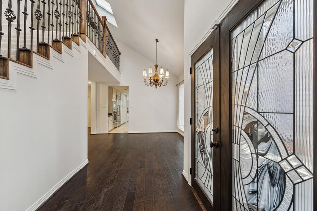 entrance foyer featuring an inviting chandelier, hardwood / wood-style flooring, french doors, and a high ceiling