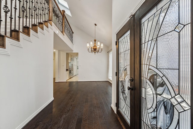 entrance foyer with french doors, a towering ceiling, hardwood / wood-style flooring, and a notable chandelier