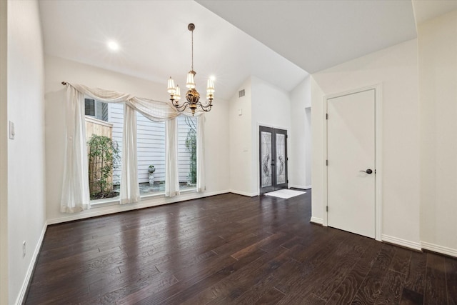 spare room featuring french doors, dark hardwood / wood-style flooring, vaulted ceiling, and a notable chandelier