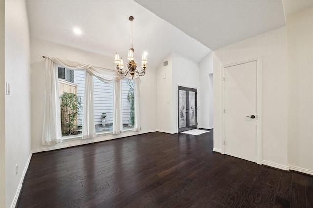 spare room with french doors, dark hardwood / wood-style floors, a chandelier, and vaulted ceiling