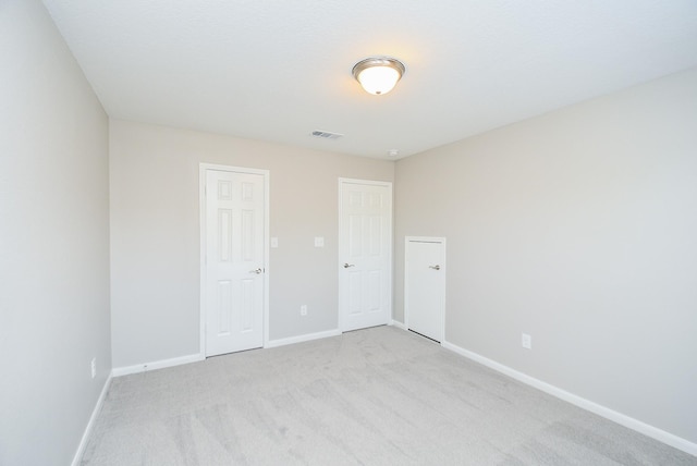 unfurnished bedroom featuring a closet and light colored carpet