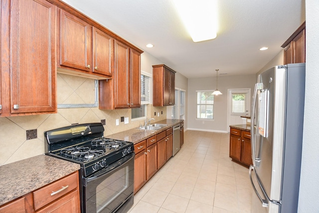 kitchen with hanging light fixtures, decorative backsplash, sink, and appliances with stainless steel finishes