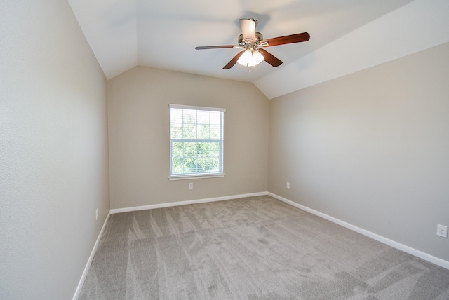 carpeted spare room featuring ceiling fan and lofted ceiling