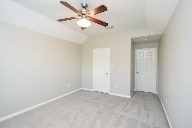 unfurnished bedroom featuring ceiling fan, light colored carpet, and lofted ceiling