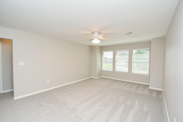 carpeted spare room featuring a textured ceiling and ceiling fan