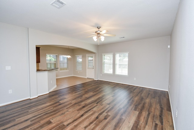 unfurnished living room with ceiling fan, dark hardwood / wood-style flooring, and plenty of natural light