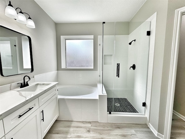 bathroom with hardwood / wood-style floors, vanity, a textured ceiling, and shower with separate bathtub