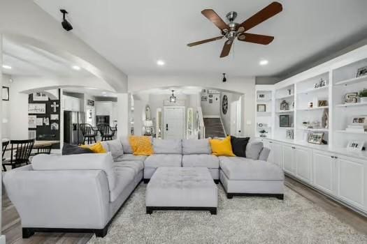 living room with light hardwood / wood-style flooring and ceiling fan