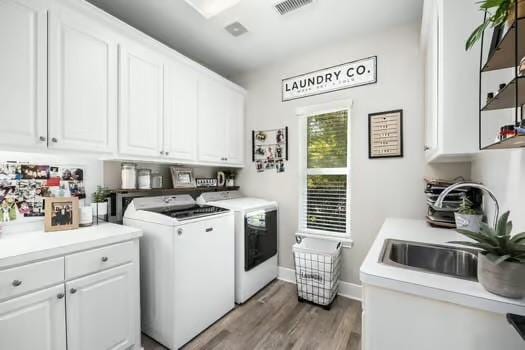 washroom with cabinets, washer and clothes dryer, dark wood-type flooring, and sink