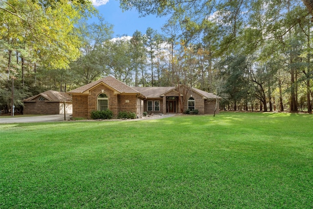 ranch-style house featuring a garage and a front lawn