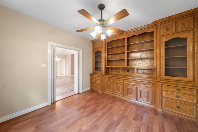 interior space with ceiling fan with notable chandelier and light hardwood / wood-style flooring