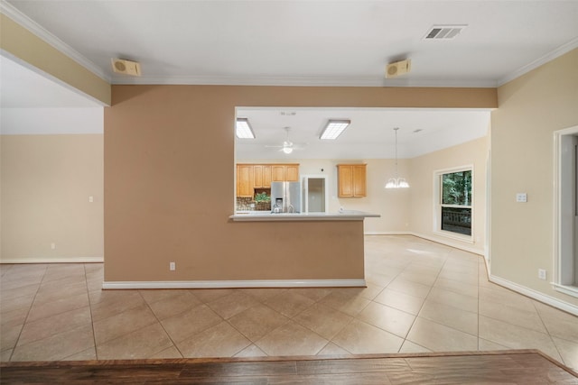 interior space featuring ceiling fan with notable chandelier, hanging light fixtures, light tile patterned floors, light brown cabinetry, and stainless steel fridge with ice dispenser