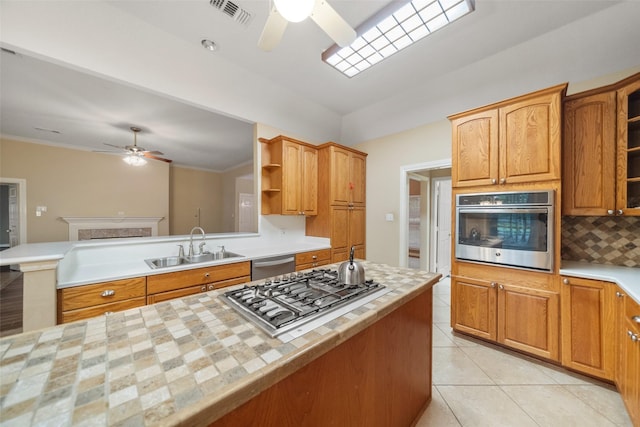 kitchen with ceiling fan, sink, backsplash, light tile patterned flooring, and appliances with stainless steel finishes