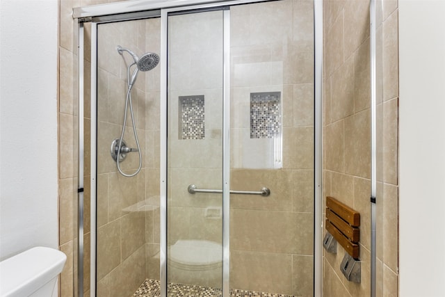 bathroom with an enclosed shower and toilet