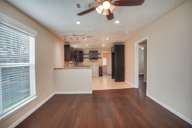 kitchen featuring a textured ceiling, dark hardwood / wood-style floors, plenty of natural light, and rail lighting