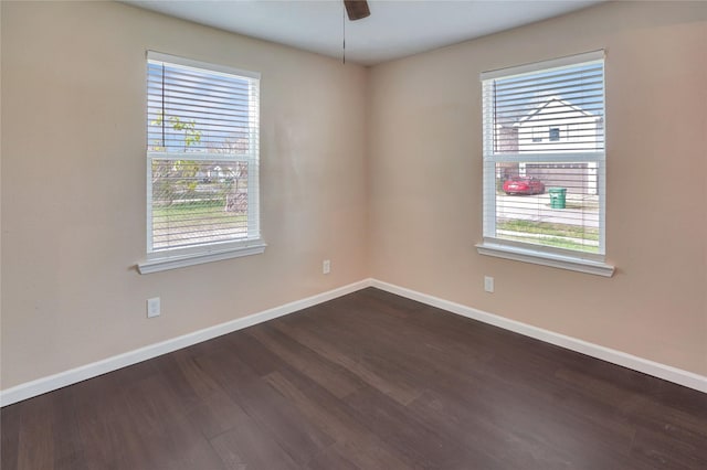 unfurnished room with ceiling fan and dark hardwood / wood-style flooring