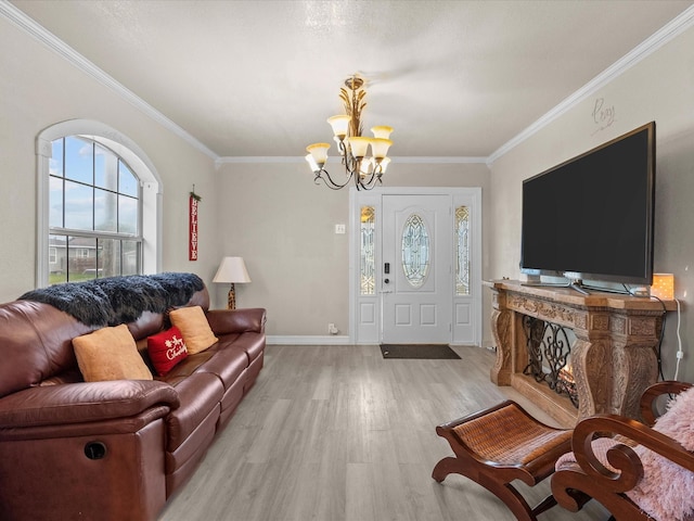 living room with light hardwood / wood-style floors, an inviting chandelier, and ornamental molding