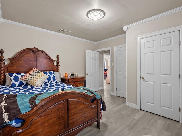 bedroom with crown molding and light hardwood / wood-style flooring