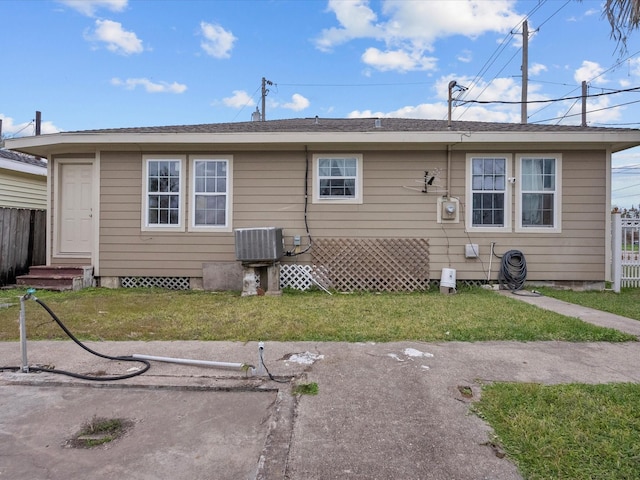 rear view of house with a yard and central AC