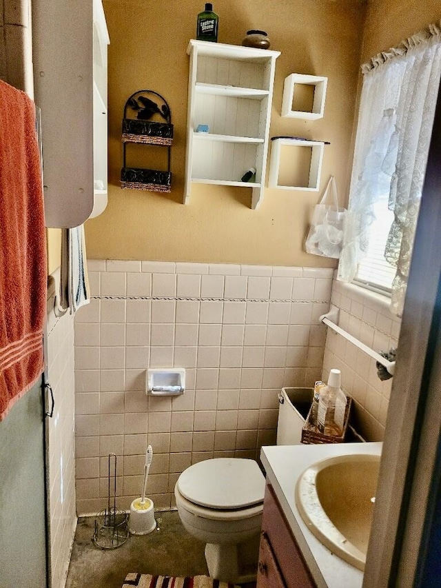 bathroom with vanity, tile walls, and toilet