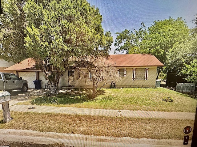 view of front of property with a front yard and a garage