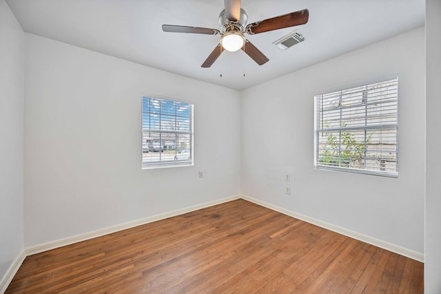 spare room with hardwood / wood-style flooring, ceiling fan, and a healthy amount of sunlight