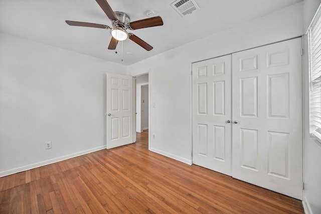 unfurnished bedroom featuring multiple windows, ceiling fan, a closet, and light hardwood / wood-style floors