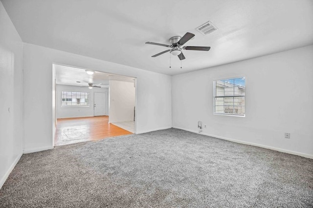 unfurnished living room featuring ceiling fan and light colored carpet