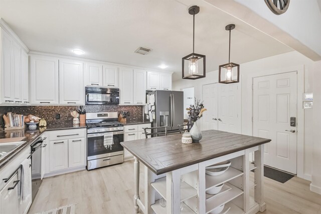 kitchen featuring decorative backsplash, white cabinetry, stainless steel appliances, and decorative light fixtures