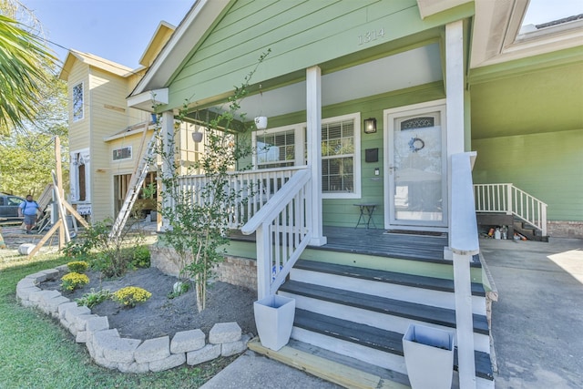 view of exterior entry featuring covered porch