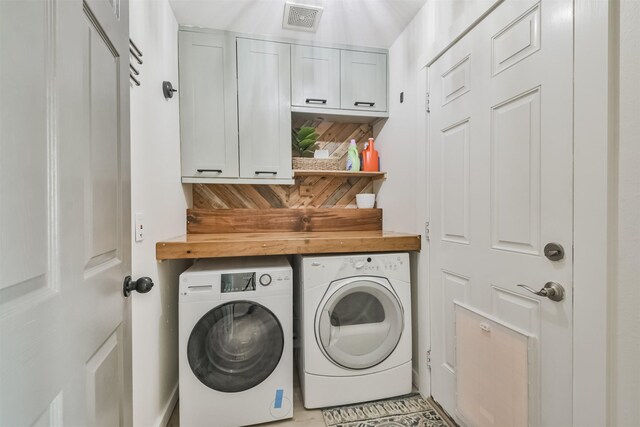 washroom with washing machine and dryer and cabinets