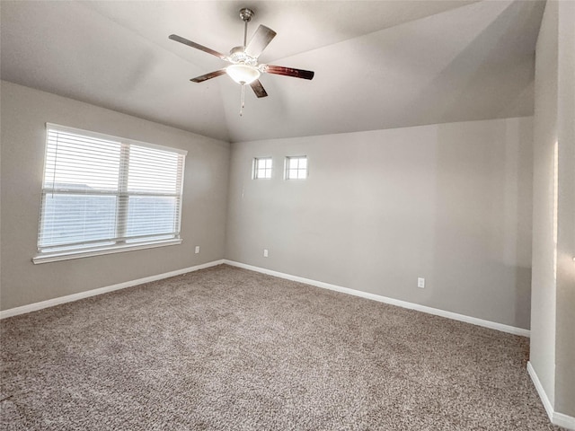 carpeted spare room with ceiling fan and vaulted ceiling