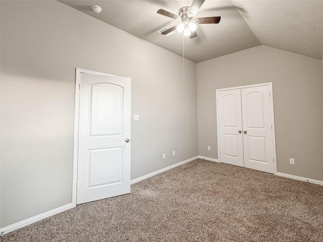 unfurnished bedroom with ceiling fan, carpet floors, and lofted ceiling