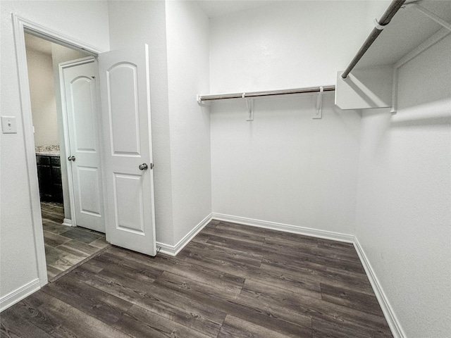 walk in closet with dark wood-type flooring