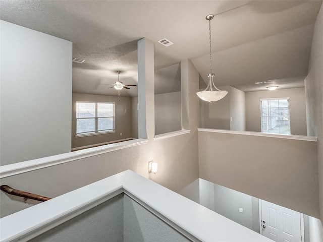 interior space featuring vaulted ceiling, a healthy amount of sunlight, and a textured ceiling