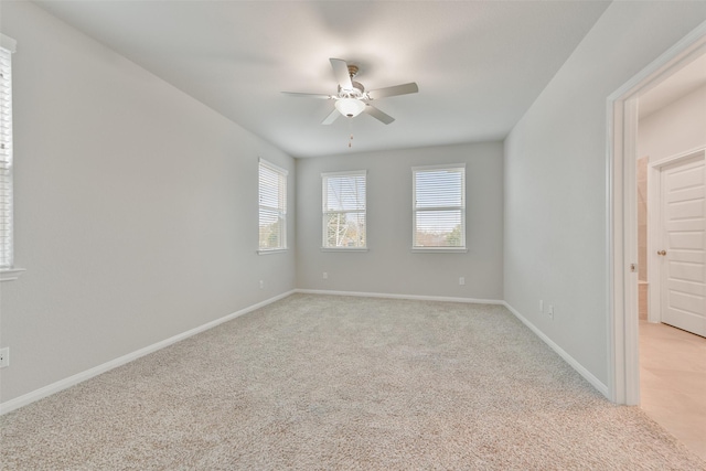 spare room featuring light carpet and ceiling fan