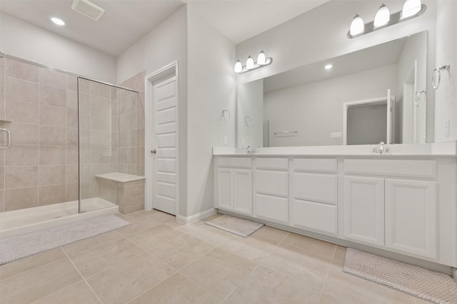 bathroom featuring tile patterned flooring, vanity, and tiled shower