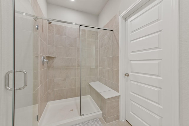 bathroom with tile patterned flooring and a shower with door