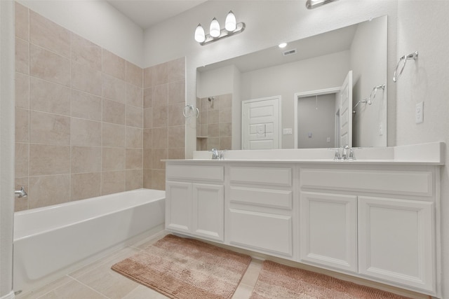 bathroom featuring tile patterned floors, vanity, and tiled shower / bath combo