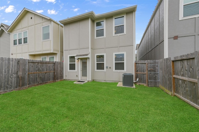 back of house featuring a yard and central air condition unit