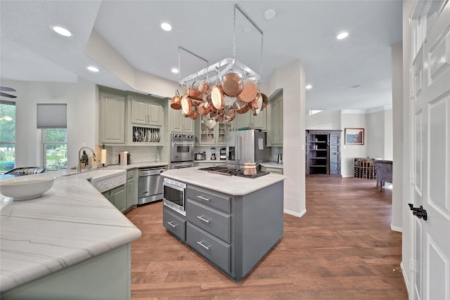 kitchen with kitchen peninsula, hardwood / wood-style floors, stainless steel appliances, and sink