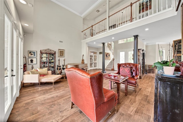 living room featuring french doors, a high ceiling, and ornamental molding