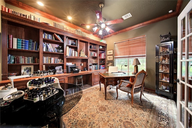 office featuring a textured ceiling, ceiling fan, and crown molding