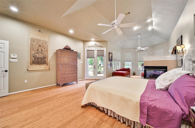 bedroom with access to exterior, french doors, ceiling fan, light hardwood / wood-style flooring, and a multi sided fireplace