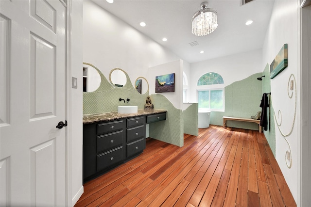 bathroom featuring hardwood / wood-style flooring, vanity, and a notable chandelier