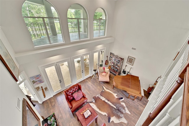 living room featuring french doors, hardwood / wood-style flooring, and a high ceiling