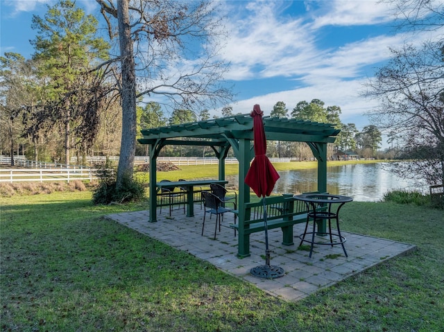 view of property's community with a yard, a pergola, a water view, and a patio area