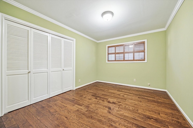 unfurnished bedroom with crown molding, a closet, and dark wood-type flooring